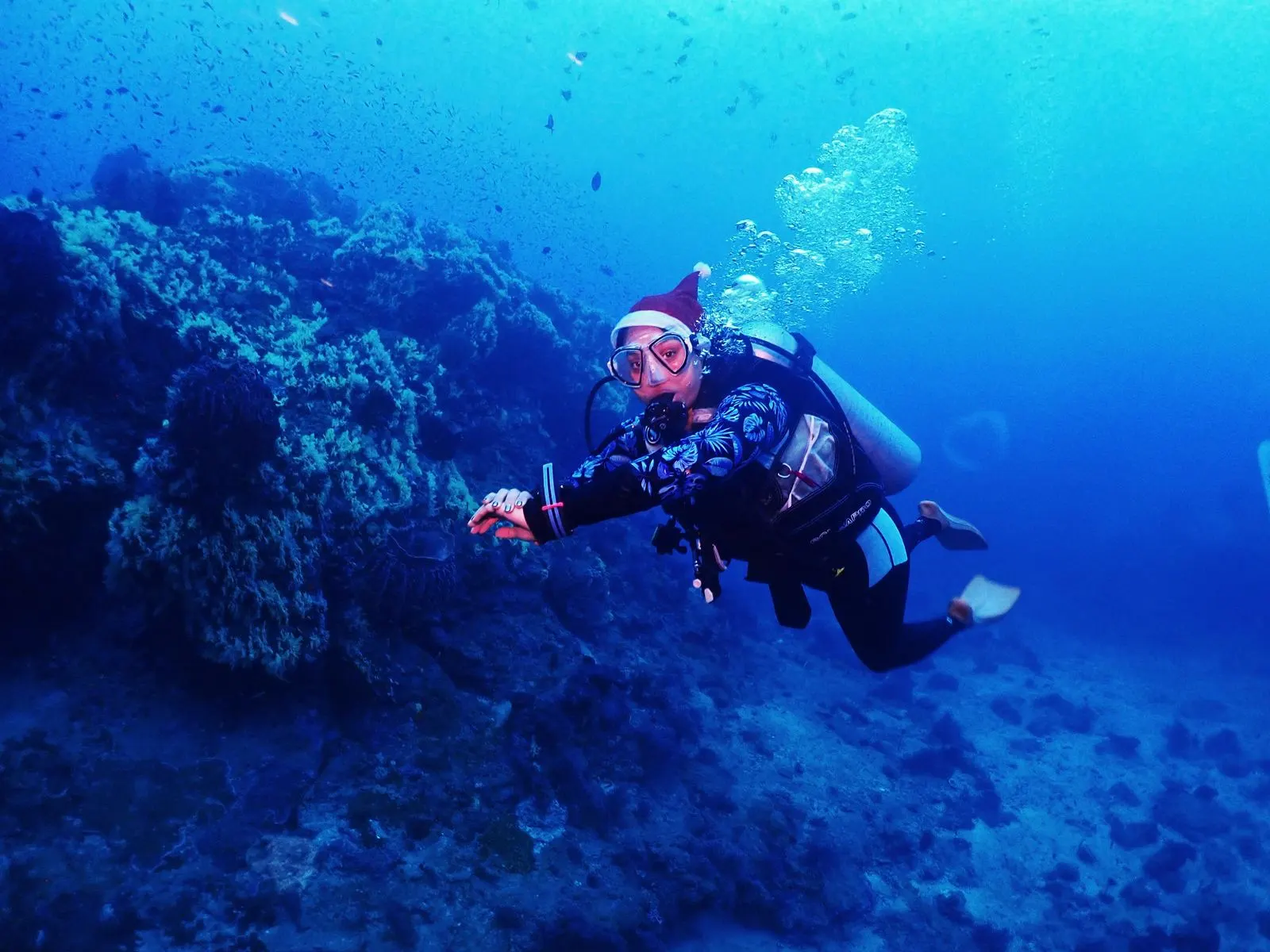Scuba diver swimming past a reef in clear blue water — SSI Specialty Nitrox Course